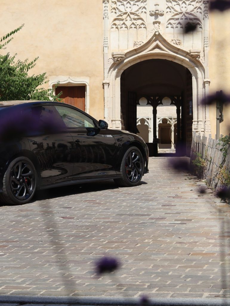 Voiture garée devant le porche gothique du cloître, dans le centre de Chalon-sur-Saône.