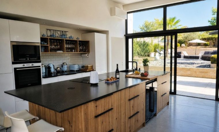 Cuisine sur mesure réalisée par la Menuiserie Moncharmont, îlot central et grande baie.